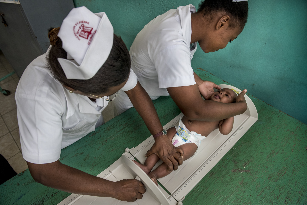 Ward and student nurses give a baby a regular check-up at a maternal and child clinic in Cap-Haitian.