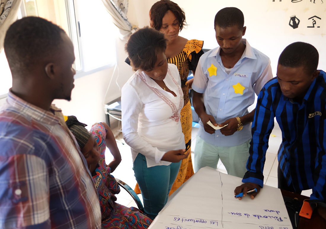 Group of people standing around a table and planning together