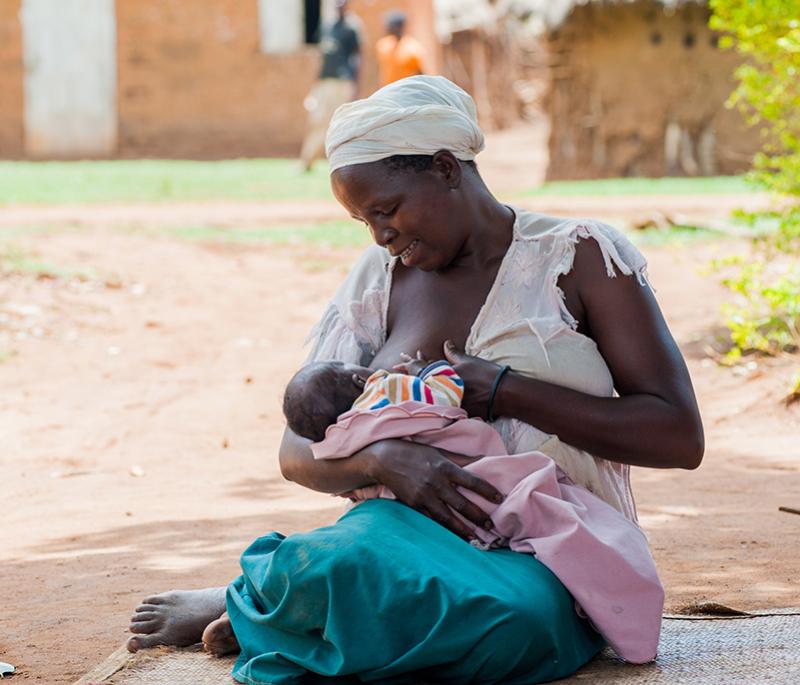 Woman Breastfeeding her small infant while outside