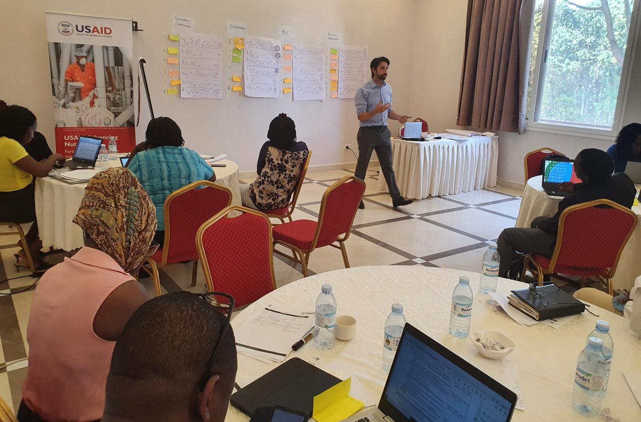 A facilitator in front of a room of people leading a session