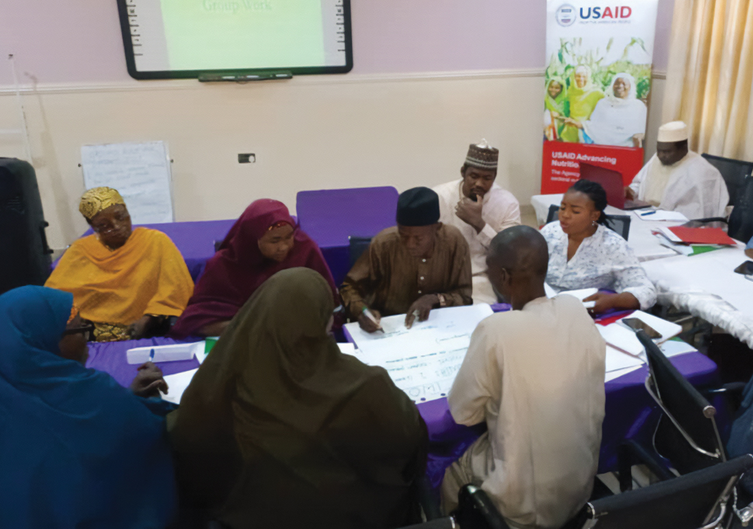 Photo of a group of health workers sitting around a conference table and learning about new forms of inpatient treatments