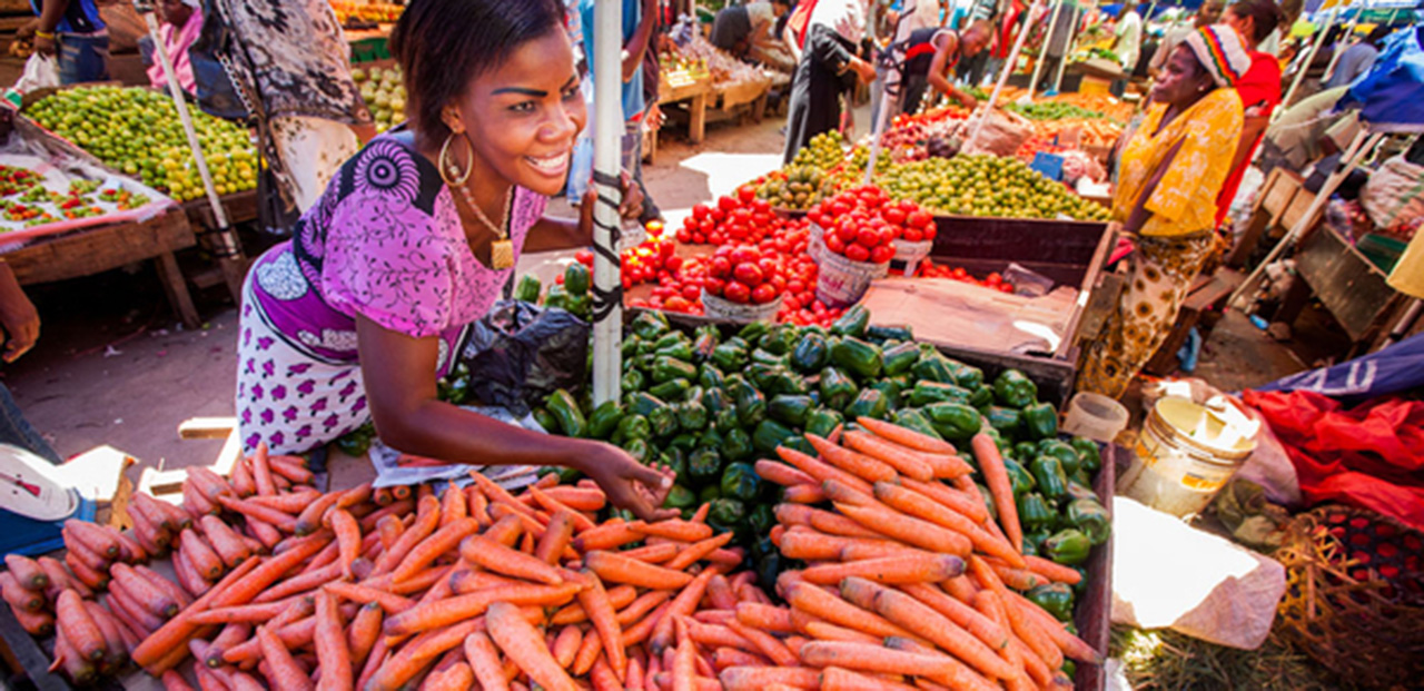 Photo of a woman selling vegetables at a market