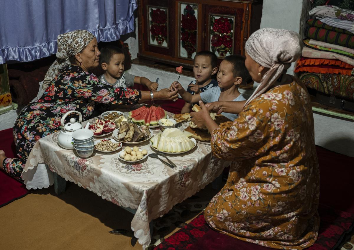 family sharing a meal seated at a low table