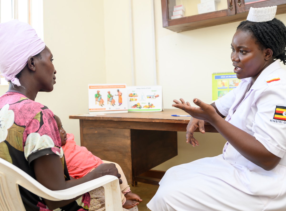 An image of a mother and child at a medical visit with a nurse.