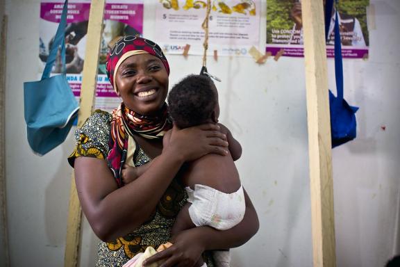 A mother holds her child while waiting to receive vaccinations at a health center in Ishaka Mberare, Uganda.