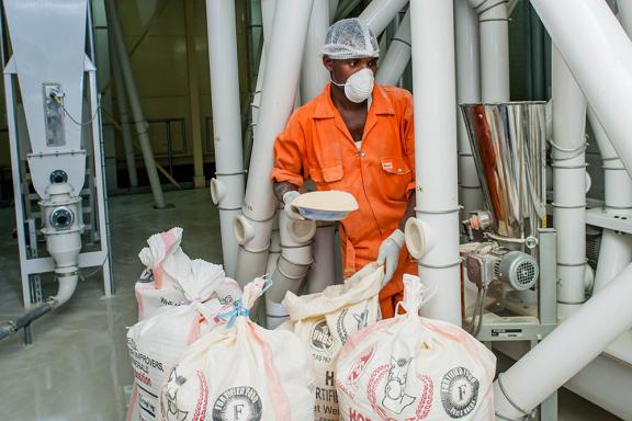 Paul Kato of Ntake Bakery and Company Limited, a wheat flour plant, adds fortificants to a dossier. 