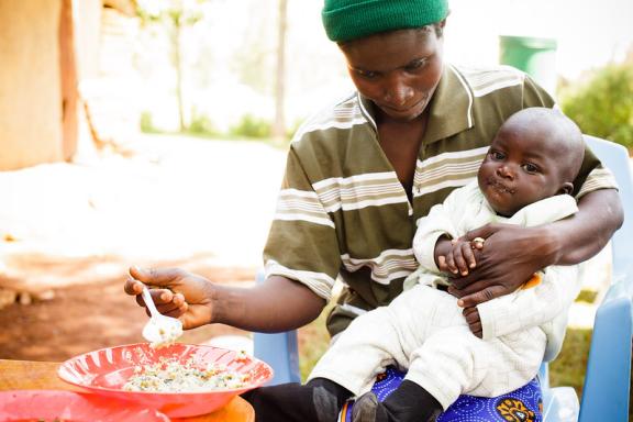 A mother feeds fortified porridge to her baby in Lwanda, Kenya.