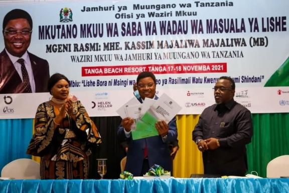 Prime Minister Honorable Kassim Majaliwa holds up hard copies of the newly launched NMNAP II Resource Mobilization Strategy. 