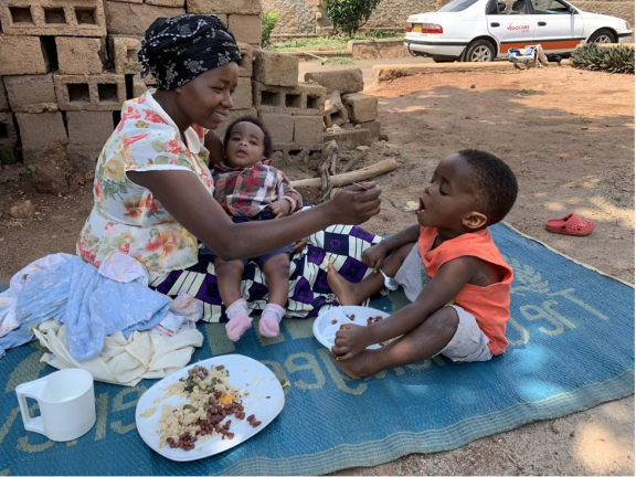 Woman feeding her two children in a park