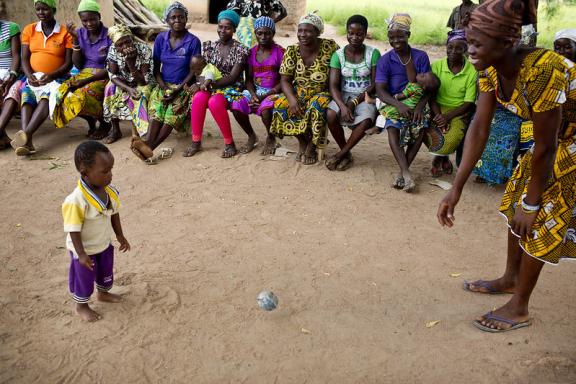 A mother and child play with a ball made out of items that can be found around the home at an Early Childhood Development session in Sijri Veng Veng Village, Ghana
