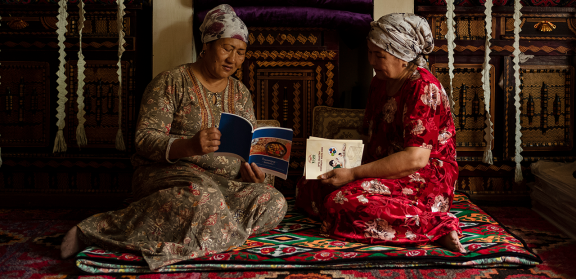 Two woman having a one on one visit in a room filled with traditional rugs