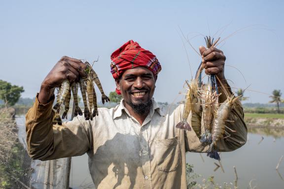 smiling man holding shellfish harvest