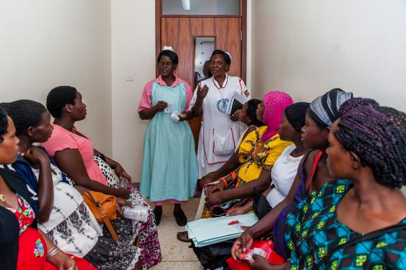 Photo of women speaking with nurses in a waiting area