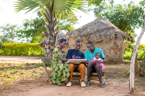 A community health worker in Uganda counsels a male and female couple on nutrition best practices.