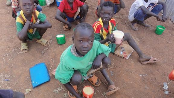 Sudanese refugee children are enjoying their school meal during break time.