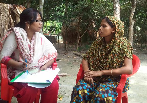 a community health work speaks with a woman in a village