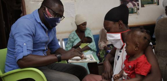 Ghana GMP Health Worker counseling mother with her toddler on her lap. Photo Credit: Kamal Deen Djabaku