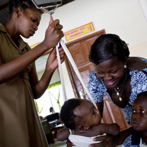 Community Health Worker weighing child