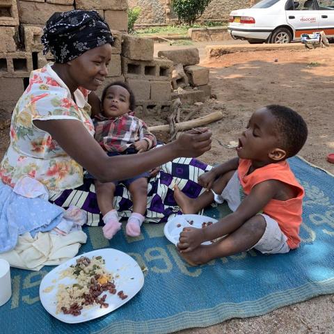 A woman feeds breakfast to a child