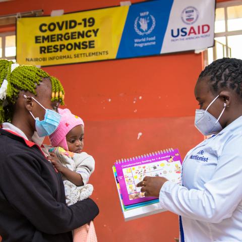 Ann Mueni, 20 with her daughter receiving the nutrition supplements from Nutritionist Alice Wanjiru during a clinic visit at Reuben Health Center