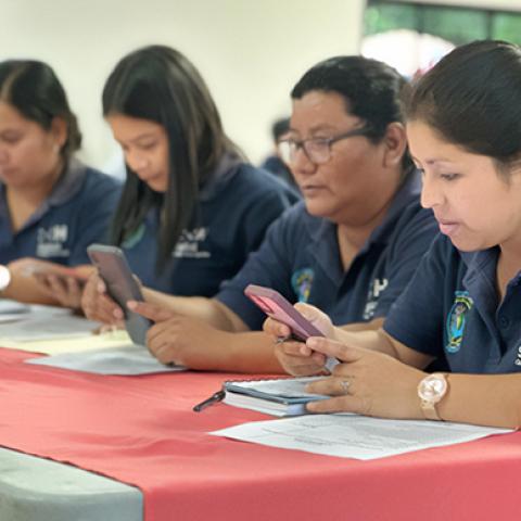 Training users on their phones for the Digital Nutrition Activities Registration Tool (REDI-AN) in a classroom, Gestor de Salud Lepaera, Lempira.