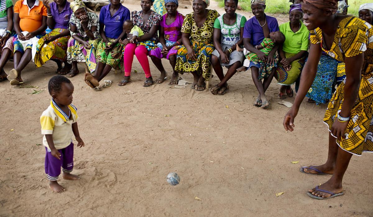A mother and child play with a ball made out of items that can be found around the home at an Early Childhood Development session in Sijri Veng Veng Village, Ghana
