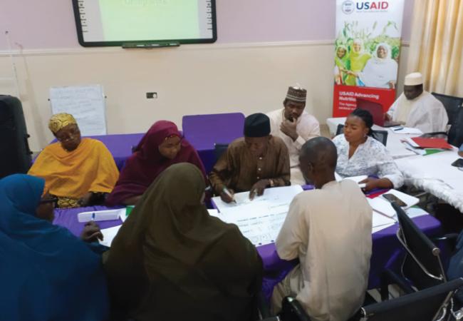 Photo of a group of health workers sitting around a conference table and learning about new forms of inpatient treatments