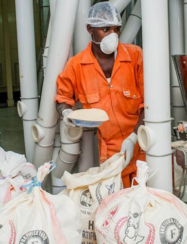 Paul Kato of Ntake Bakery and Company Limited, a wheat flour plant, adds fortificants to a dossier.